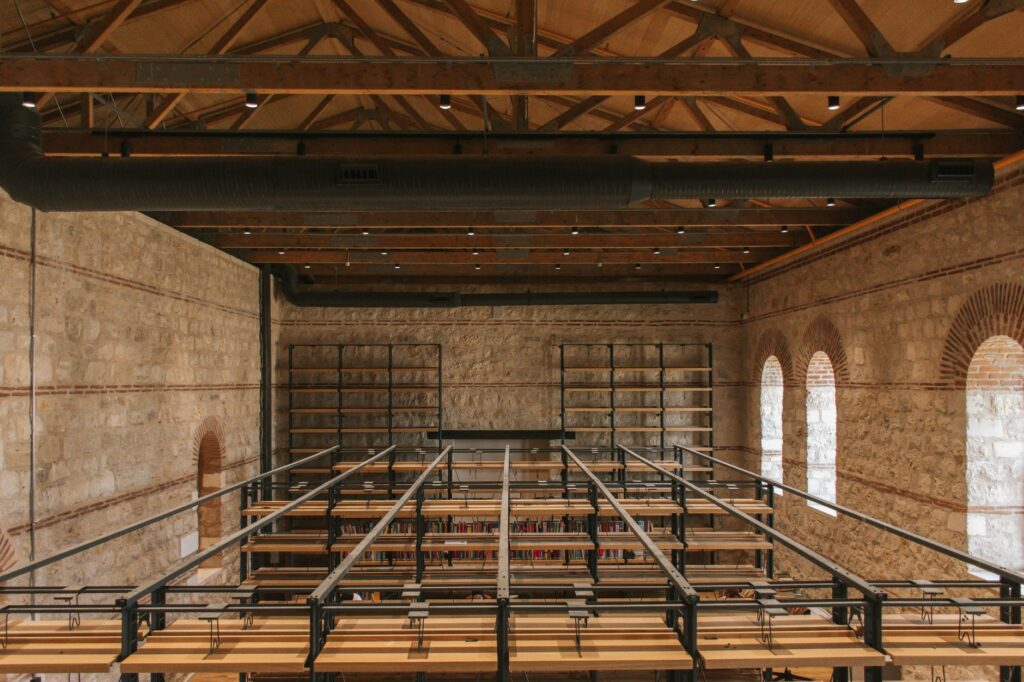 Vintage library interior with wooden beams and brick walls, showcasing a unique rustic design.
